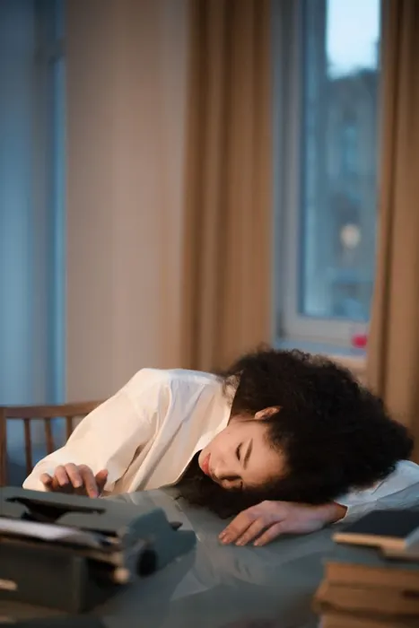 Exhausted woman resting her head on the table in the afternoon